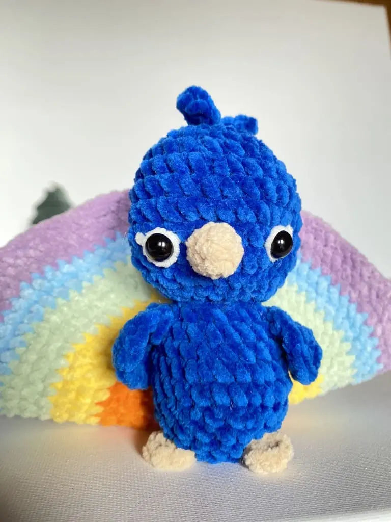 A blue peacock with a rainbow tail from tchiptchip a crochet pattern shop
