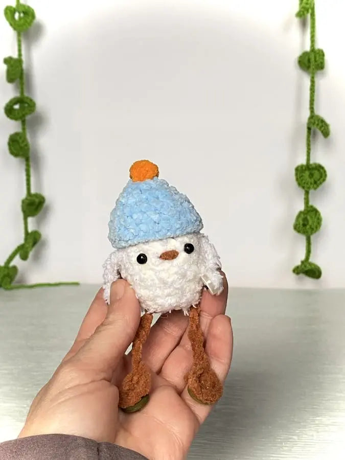 Crochet duckling with a blue hat and an orange pom-pom