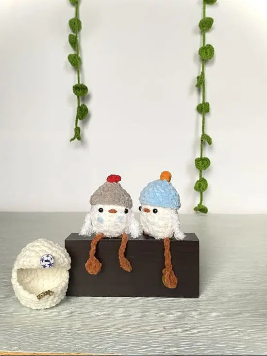 two adorables crocheted ducklings with a beanie grey and blue