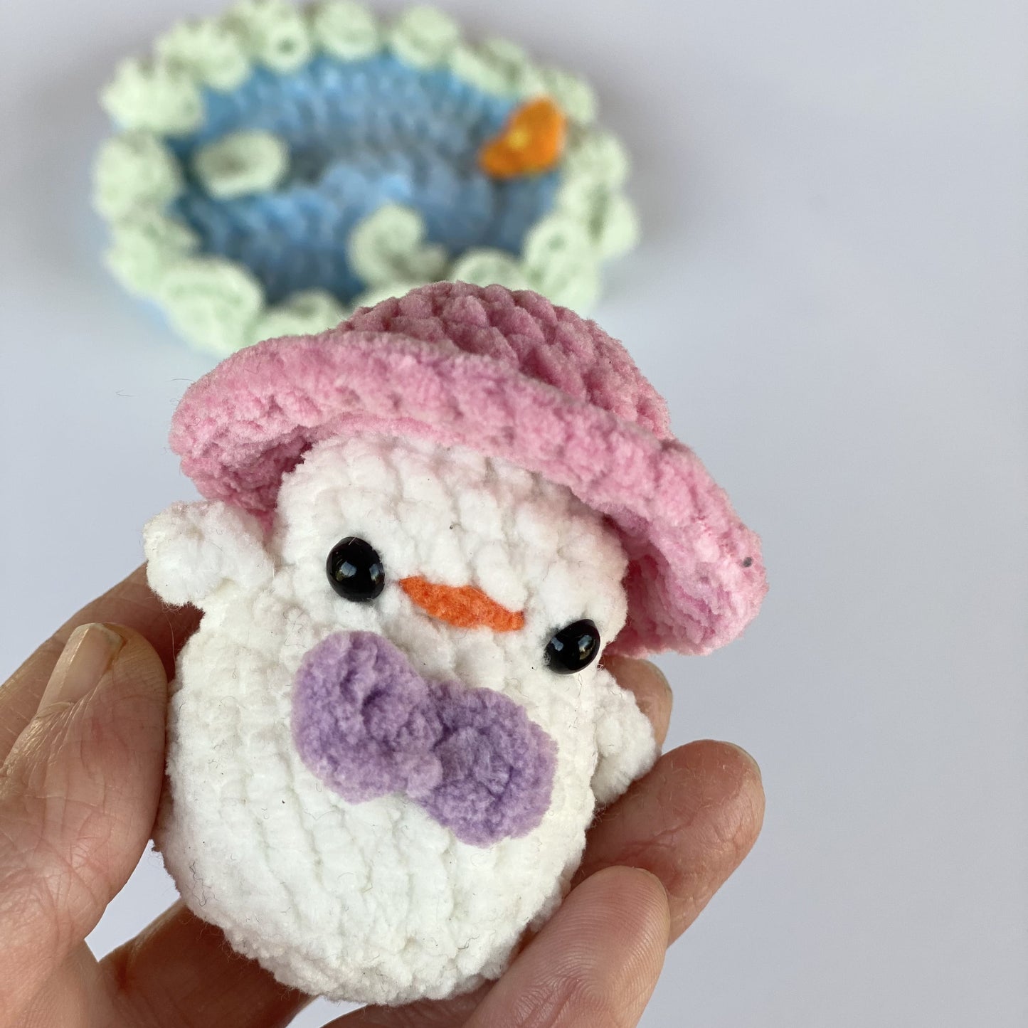 Duck crocheted with a pink hat and a mauve bow tie