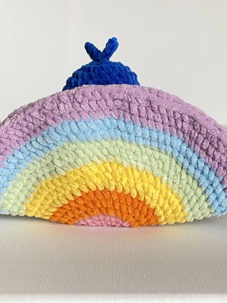 A blue peacock seen from behind with a rainbow tail from tchiptchip a crochet pattern shop
