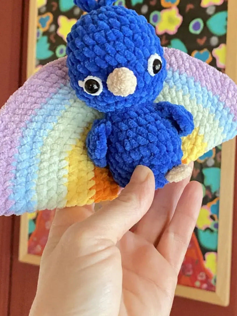 A blue peacock with a rainbow tail from tchiptchip a crochet pattern shop